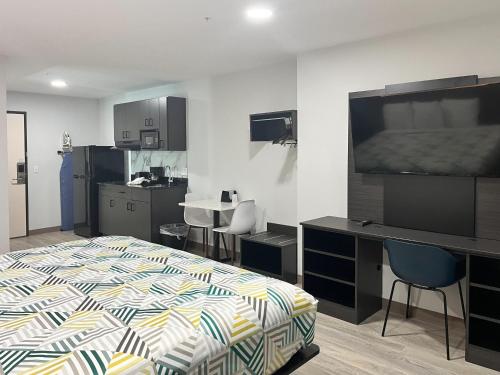 a bedroom with a bed and a desk with a television at Motel 6 Gonzales, LA Baton Rouge Geismar Prairieville I 10 in Gonzales