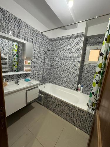 La salle de bains est pourvue d'une baignoire et d'un lavabo. dans l'établissement Have a fun in blida, à Dilida