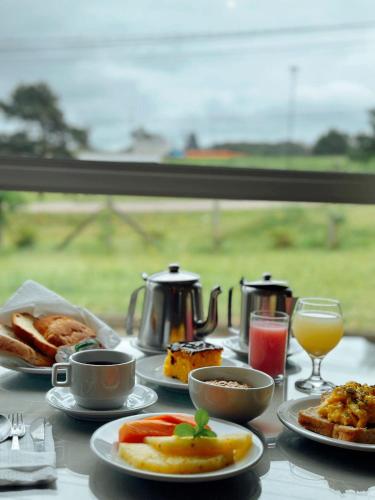 a table topped with plates of food and cups and drinks at Harbor Self Graciosa Hotel in Quatro Barras