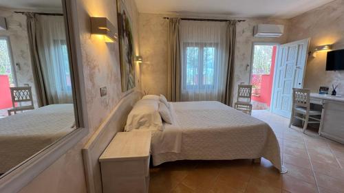 a bedroom with two beds and a mirror at Borgo di Santa Barbara in Santa Domenica