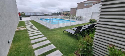a backyard with a swimming pool and some chairs at Vive Alto Reñaca in Viña del Mar