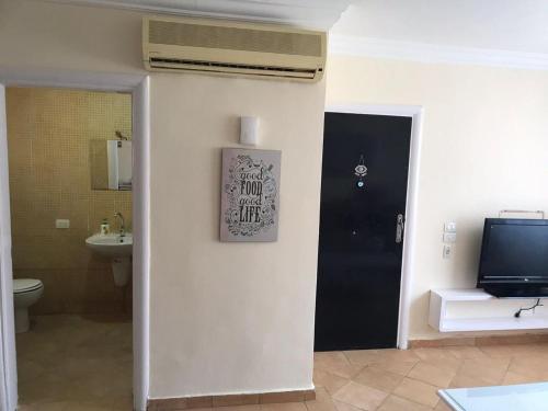 baño con aseo y TV en la pared en Serra Resort-Napa- Great Area en Sharm El Sheikh