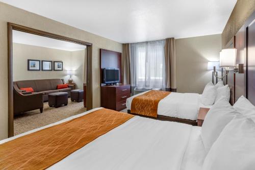 a hotel room with two beds and a living room at Comfort Inn Layton - Salt Lake City in Layton