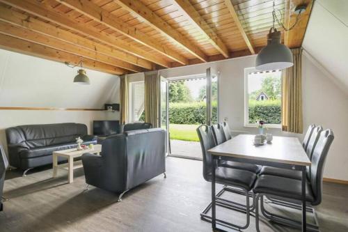a living room with a table and chairs and a couch at Vakantiebungalow Het Egelhuis in Gramsbergen