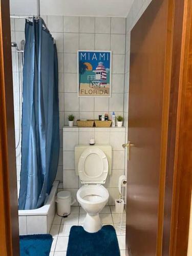 ドルトムントにあるDortmund City! Apartment DREAMのバスルーム(トイレ、青いシャワーカーテン付)