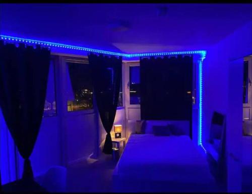 ドルトムントにあるDortmund City! Apartment DREAMのベッドと青いライト付きのダークルーム