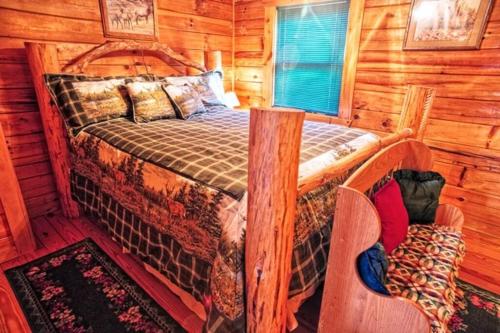1 dormitorio con 1 cama en una cabaña de madera en Mick's Hideaway - Semi-Secluded en Sevierville
