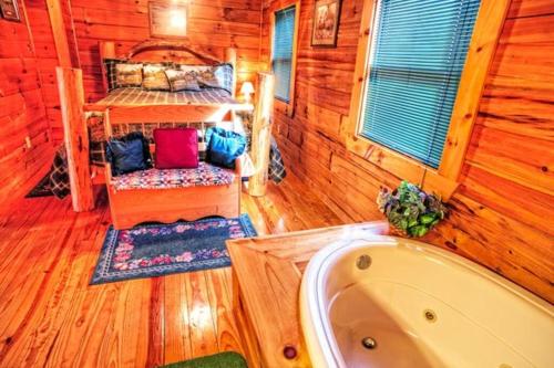 a room with a bed and a tub in a cabin at Mick's Hideaway - Semi-Secluded in Sevierville