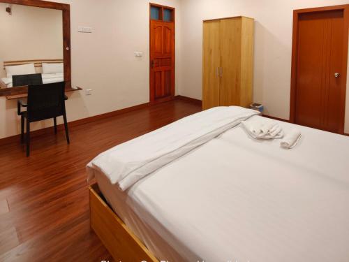 1 dormitorio con 1 cama con escritorio y silla en Oi Beach en Maamigili