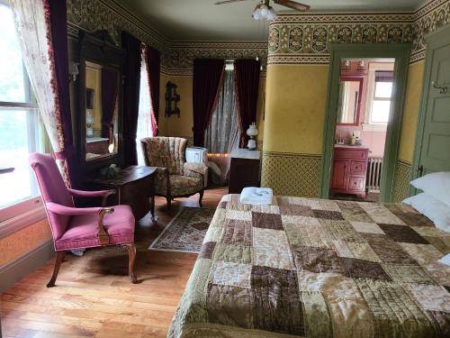 1 dormitorio con 1 cama, mesa y sillas en Scottwood Inn, en Toledo