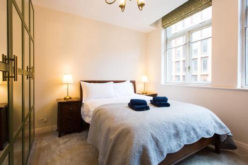 1 dormitorio con 1 cama con 2 toallas azules en Stylish City Centre 2 Bed Apartment - Free Parking, en Mánchester