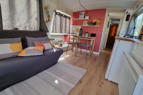 ein Wohnzimmer mit einer Couch in einem winzigen Haus in der Unterkunft Bateau Le Chassane in Baume-les-Dames