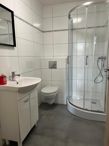 a bathroom with a shower and a toilet and a sink at Pension Wolkenheim 