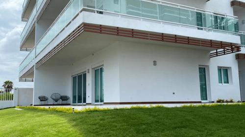 a white house with two chairs in the yard at Pacifika Marina Mazatlán in Mazatlán