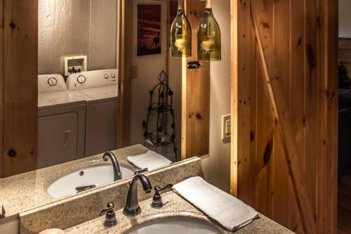 La salle de bains est pourvue d'un lavabo et d'un grand miroir. dans l'établissement Holly Tree Hideaway - Semi Secluded Mtn Setting, à Sevierville