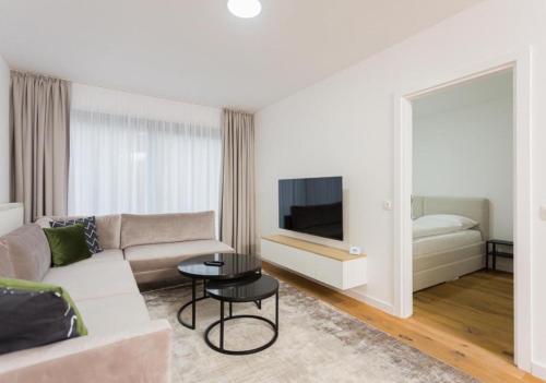 sala de estar blanca con sofá y TV en Deluxe Apartman Grey, en Bjelašnica
