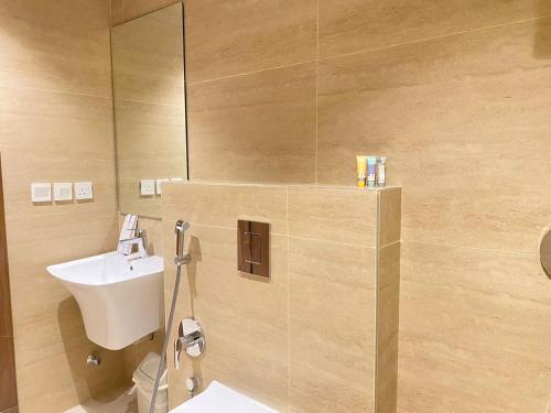 a bathroom with a sink and a toilet and a mirror at Nuzul R157 - Elegant Apartment in Riyadh