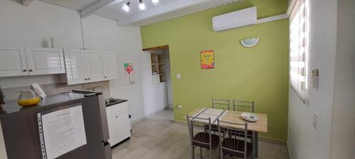 een keuken met groene muren en een tafel en stoelen bij LUCA apartment 5H in Noord