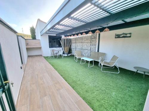 un patio al aire libre con mesa, sillas, mesa y sillas en Studio moderne avec jardin Côte Bleue en Le Rove