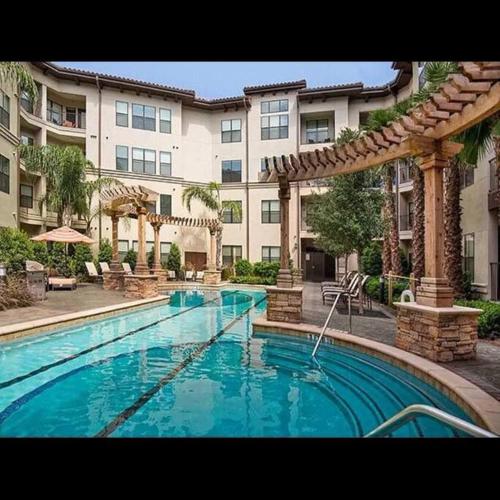 a swimming pool in front of a large building at Fantastic 1-Bedroom Close to Reliant Stadium & Medical Center in Houston