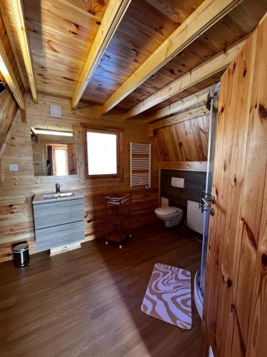 - une salle de bains dans une cabane en rondins avec lavabo et toilettes dans l'établissement Cabane Ardennaise, à Fromelennes