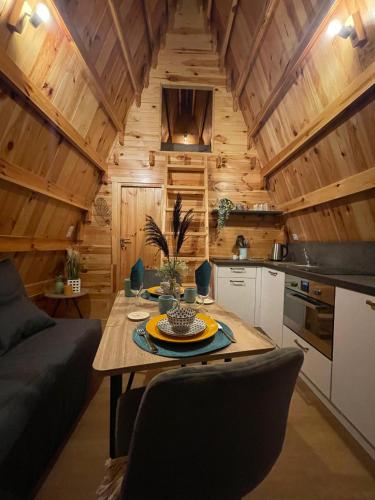 - une cuisine et un salon avec une table dans une cabine dans l'établissement Cabane Ardennaise, à Fromelennes