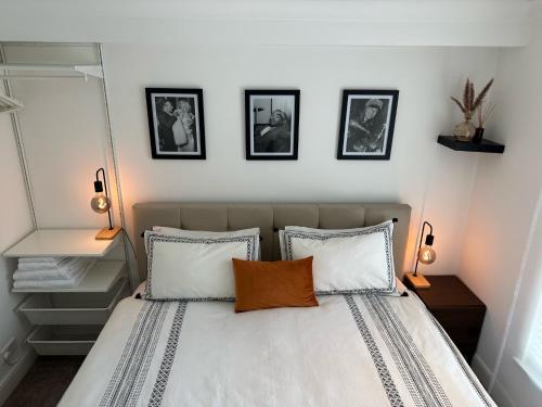 Stylish One Bedroom Flat Chancery Lane في لندن: غرفة نوم بسرير بثلاث صور على الحائط