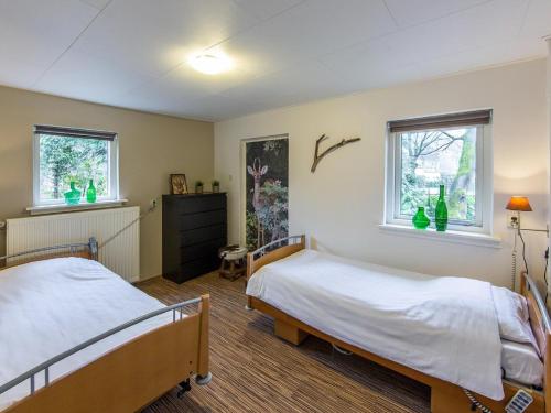 een slaapkamer met 2 bedden en 2 ramen bij Beautiful home with lots of privacy, in the forest in De Bult