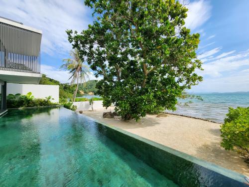 an infinity pool with a view of the ocean at Luxury Beachfront AMANA Villa 4 Br at Ta-Ke Residence A in Phuket