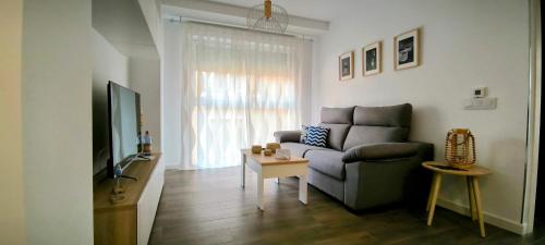 a living room with a couch and a table at El sueño de Noctiluca in Rincón de la Victoria