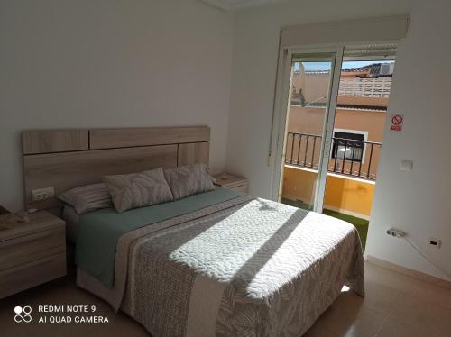 1 dormitorio con 1 cama y balcón en La casita de Daniel, en Turís