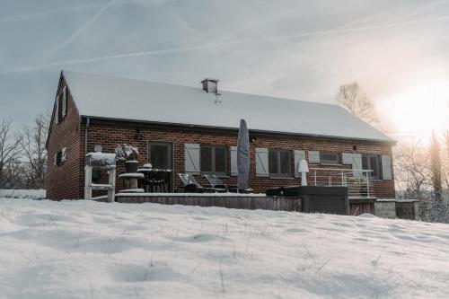 a brick house with snow on the ground in front of it at Villa ADurbuy avec Jacuzzi in Durbuy