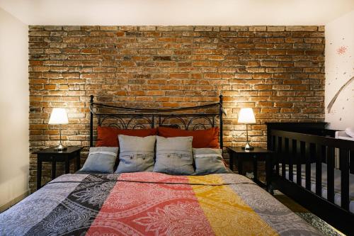 a bed in a room with a brick wall at Apartmán V medvědím brlohu in Dolní Lomná