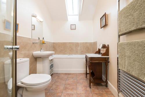 La salle de bains est pourvue de toilettes, d'un lavabo et d'une baignoire. dans l'établissement Incheoch Farm Granary, à Alyth