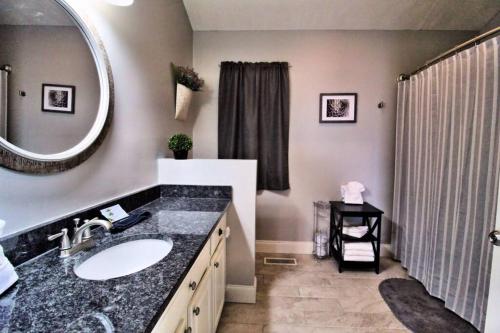 a bathroom with a sink and a mirror and a shower at Mountain Escape Chalet-Paradise! in Gatlinburg