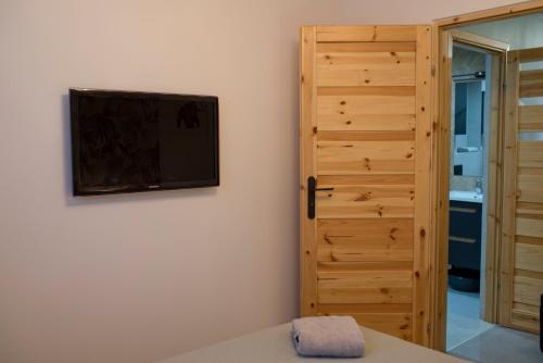 a bedroom with a tv on the wall next to a door at Go2Krynica - Pod Jaworzyną in Krynica Zdrój
