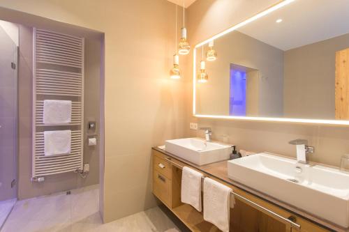 a bathroom with two sinks and a mirror at Alpenhotel Ischglerhof in Ischgl