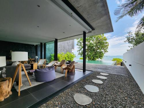 una sala de estar de planta abierta con vistas al océano en Beachfront 3 Bedrooms - AMANA Villa at Ta-Ke Residence Phuket, en Phuket