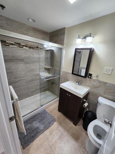 a bathroom with a shower and a toilet and a sink at Sophisticated 4-Bed Apt Close to NYC in Jersey City