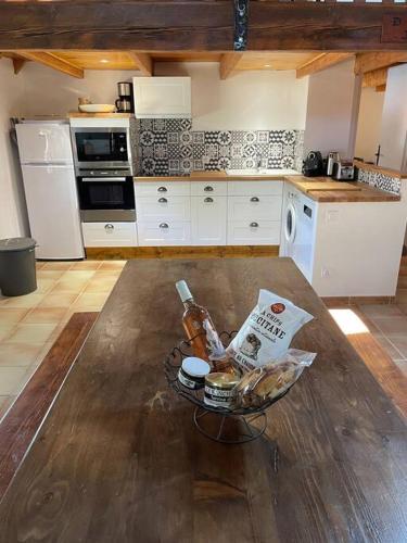 une cuisine avec des armoires blanches et un plancher en bois dans l'établissement Maison de gardians traditionnelle - Espiguette, au Grau-du-Roi