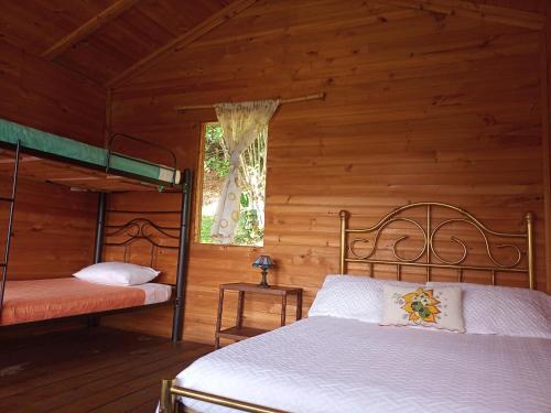 a bedroom with two bunk beds in a log cabin at Eco-Cabañas Altozano Nimaima in Nimaima