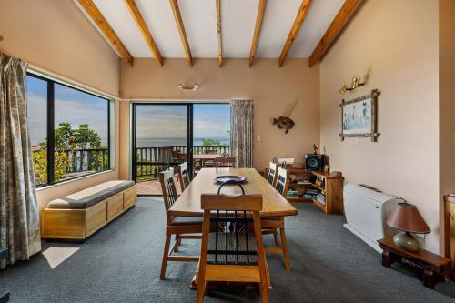 een woonkamer met een tafel en een groot raam bij Pukawa Paradise - Pukawa Holiday Home in Kuratau