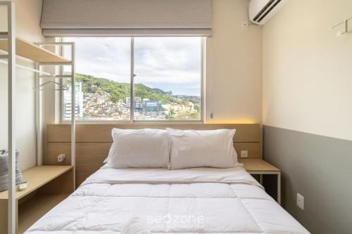 a bedroom with a bed and a large window at Apto confortável vista mar em Floripa EVA704 in Florianópolis