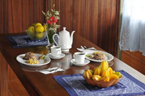 un tavolo con piatti di cibo e un cesto di frutta di Casa Drake Lodge a Bahía Drake