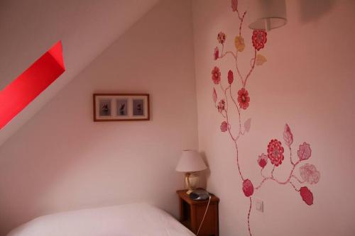 1 dormitorio con cama y pared roja en Chez Édouard et Aline en Ploubazlanec