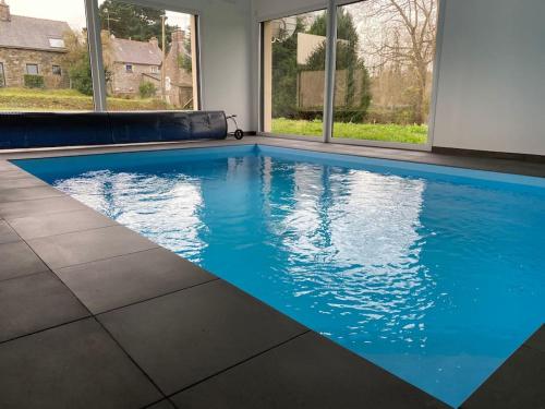 een zwembad met blauw water in een huis bij La maison du bonheur in Trémeven