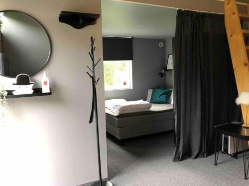 - une petite chambre avec un lit et un miroir dans l'établissement Hässleholm med närhet till strövområde och sjö, à Tormestorp