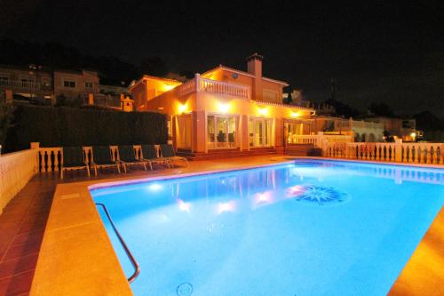 una piscina frente a una casa por la noche en Ty Croeso-Entire villa with sea view, en Calpe