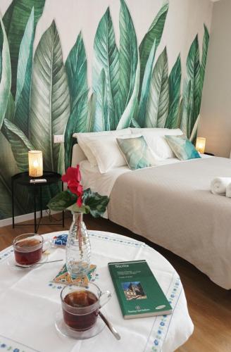 a room with two beds and a table with a vase at Casa D'Antò in Petralia Sottana