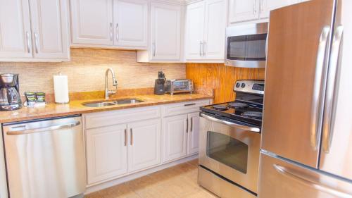 a kitchen with white cabinets and a stainless steel refrigerator at Little Smoky Retreat , 3 Bedroom , Close to downtown Gatlinburg AND Pigeon Forge in Gatlinburg